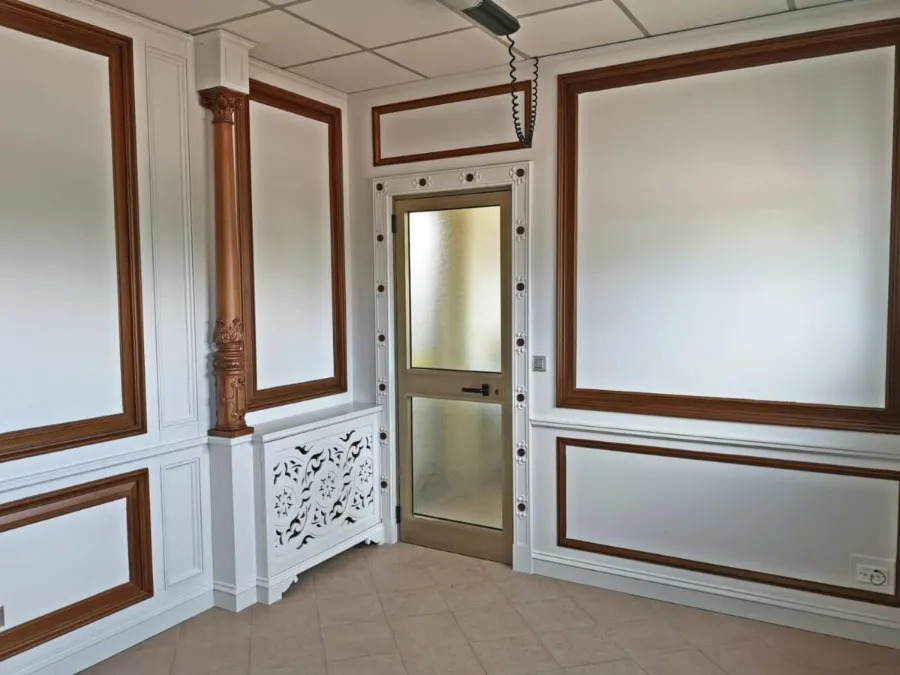 Boiserie bianca con cornici in noce e colonna intagliata