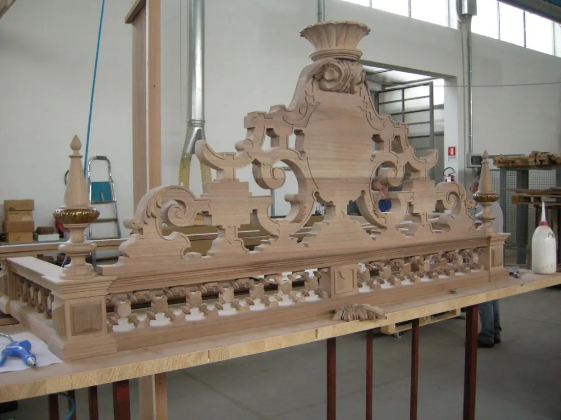 Fregio barocco intagliato in legno appoggiato sul banco del laboratorio